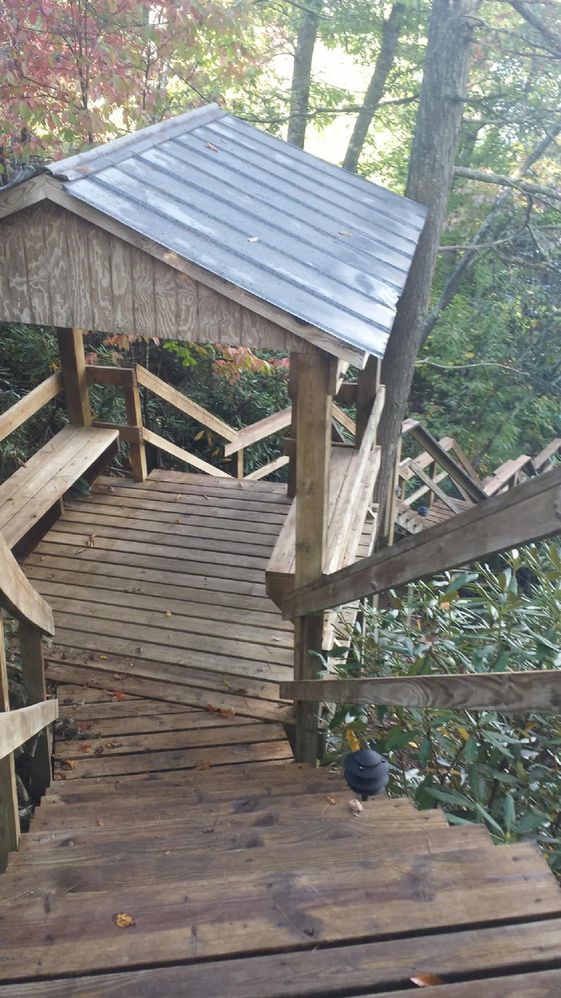Metal roofed shelter over wooden steps on a wooded walkway — Skylight Repair & Installation work by our crew in Mechanicsville